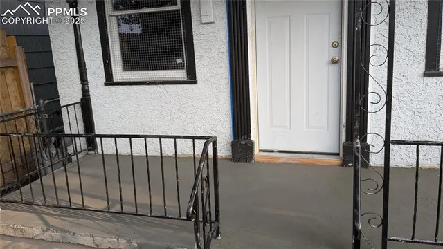 a view of a house with a small yard and wooden fence