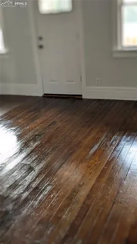 a view of a room with wooden floor and a window