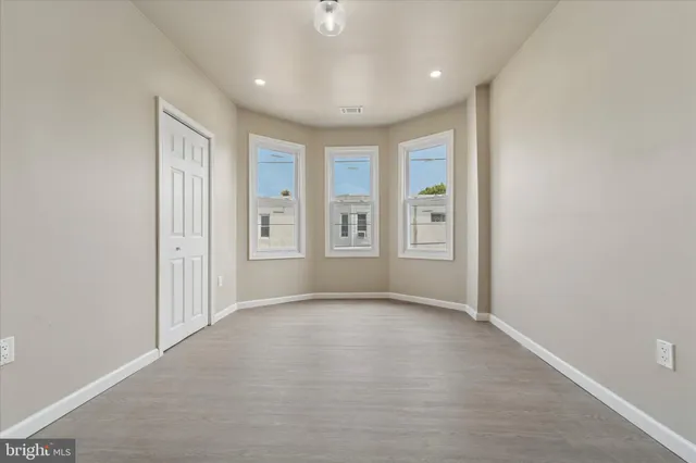 an empty room with windows and closet