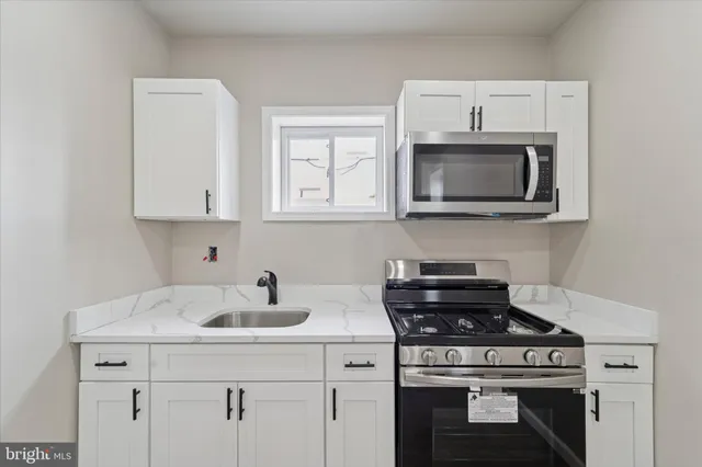 a kitchen with cabinets stainless steel appliances and a sink