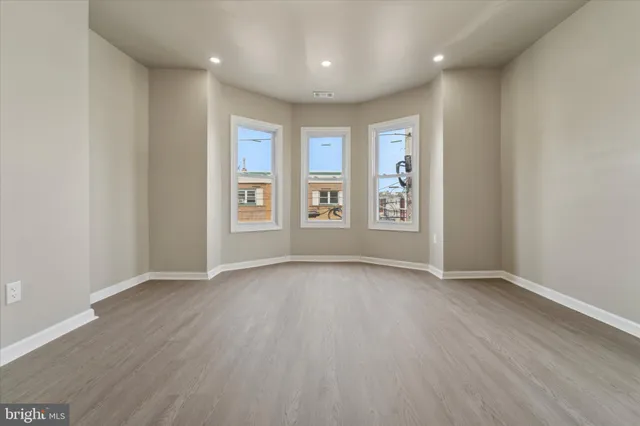wooden floor in an empty room with a window
