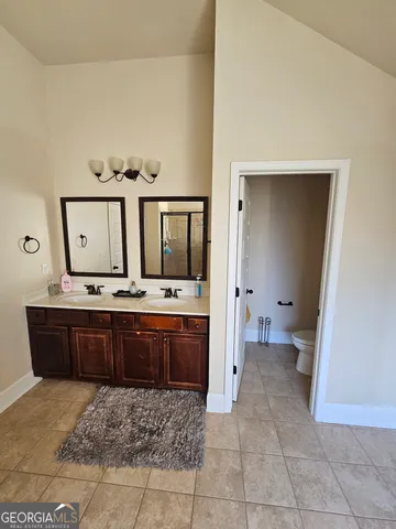 a large bathroom with a vanity a sink a mirror and a bathtub