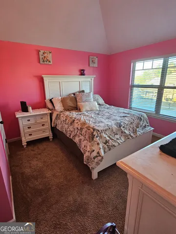 a bed sitting in a bedroom next to a window