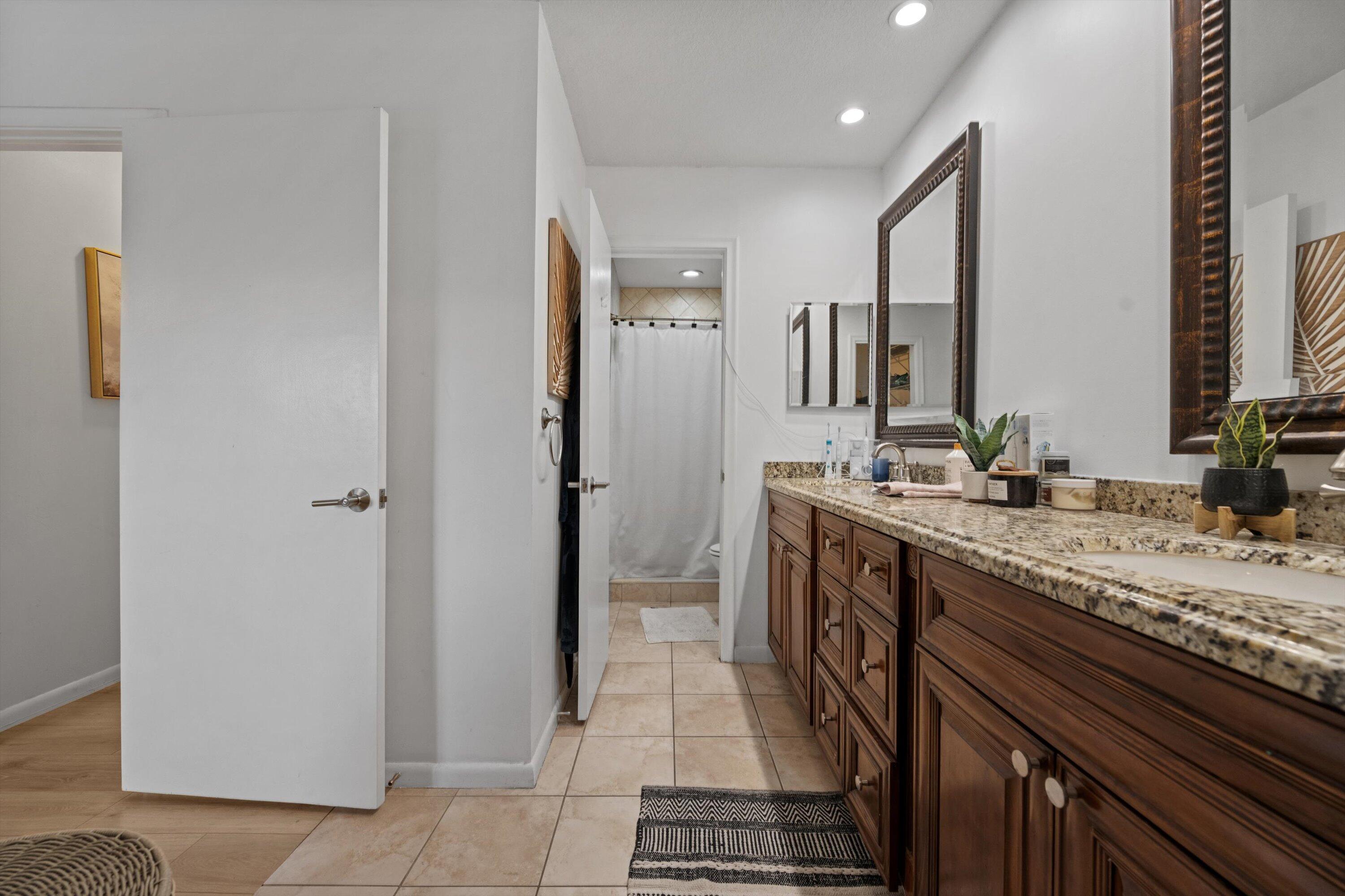 404 Pine Tree Court, Unit 6 Atlantis, FL 33462 - Photo 15 of 26 a spacious bathroom with a granite countertop sink a mirror and a shower