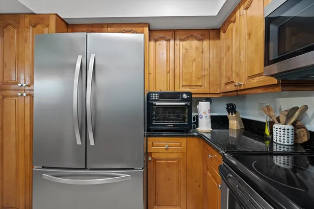 a kitchen with stainless steel appliances granite countertop a refrigerator a stove and a sink