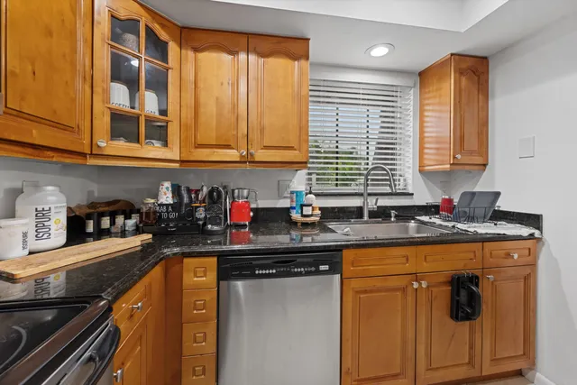 a kitchen with stainless steel appliances granite countertop a sink stove and cabinets