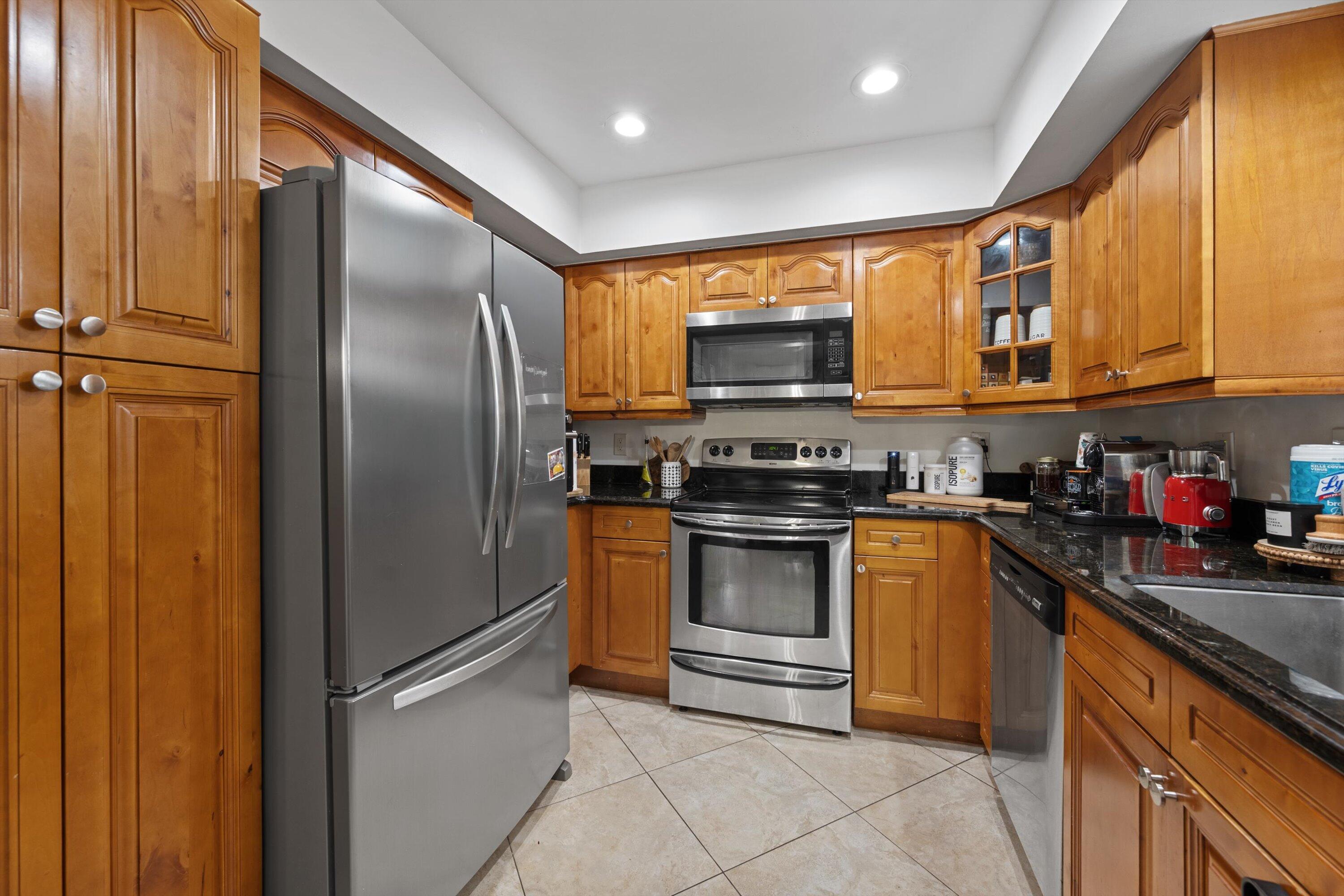 404 Pine Tree Court, Unit 6 Atlantis, FL 33462 - Photo 8 of 26 a kitchen with stainless steel appliances a refrigerator and a stove top oven