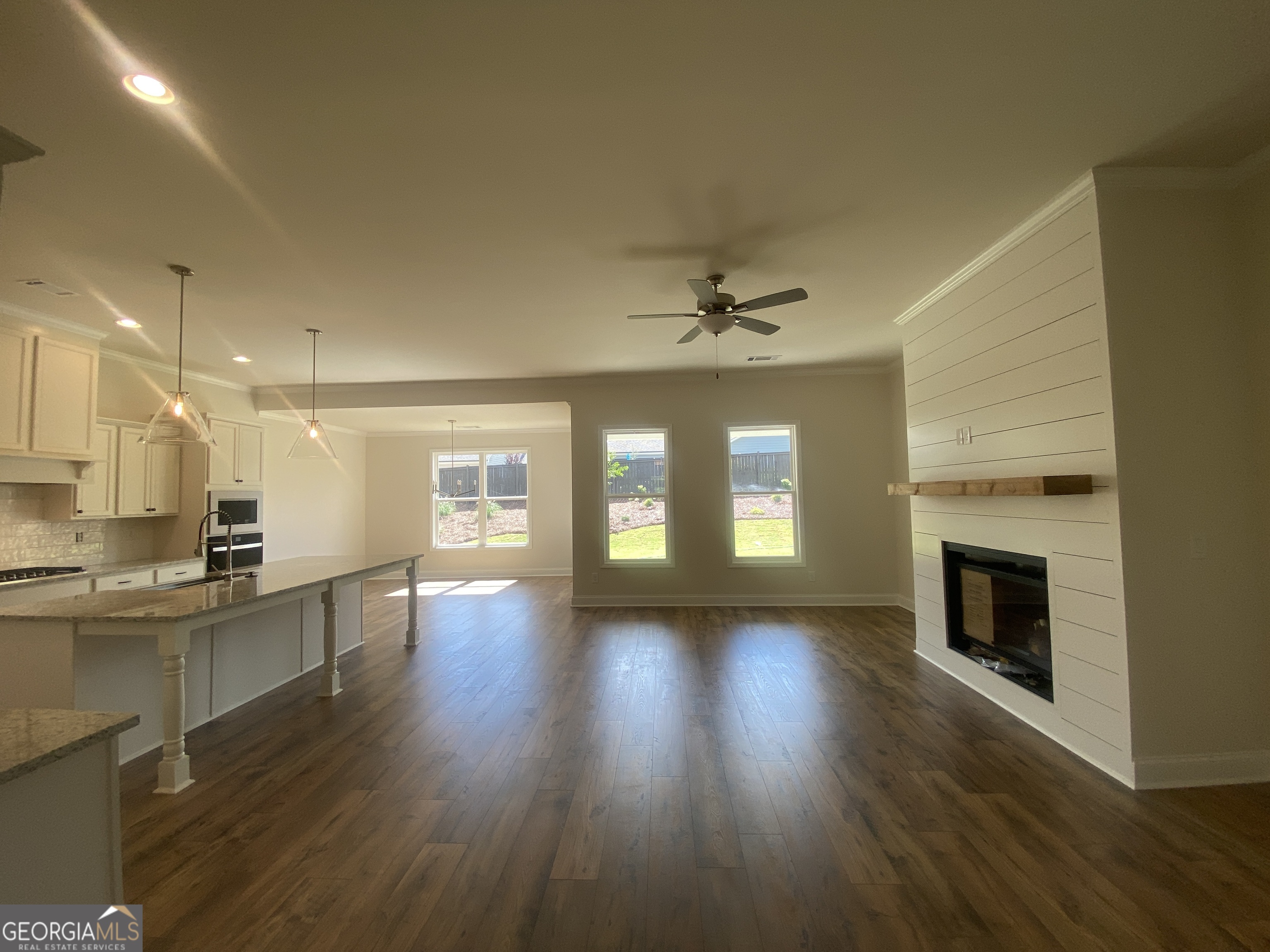 134 Oakdale Road, Unit 31 Jefferson, GA 30549 - Photo 9 of 60 a view of an empty room with wooden floor and a kitchen