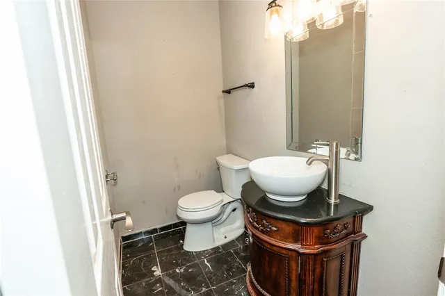 a bathroom with a toilet a sink and mirror