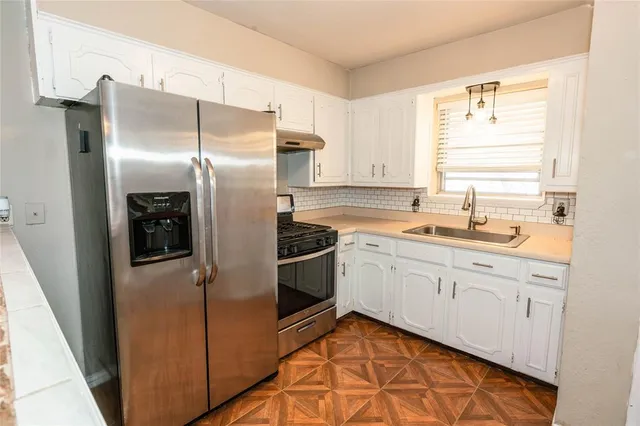 a kitchen with stainless steel appliances granite countertop a refrigerator and a sink