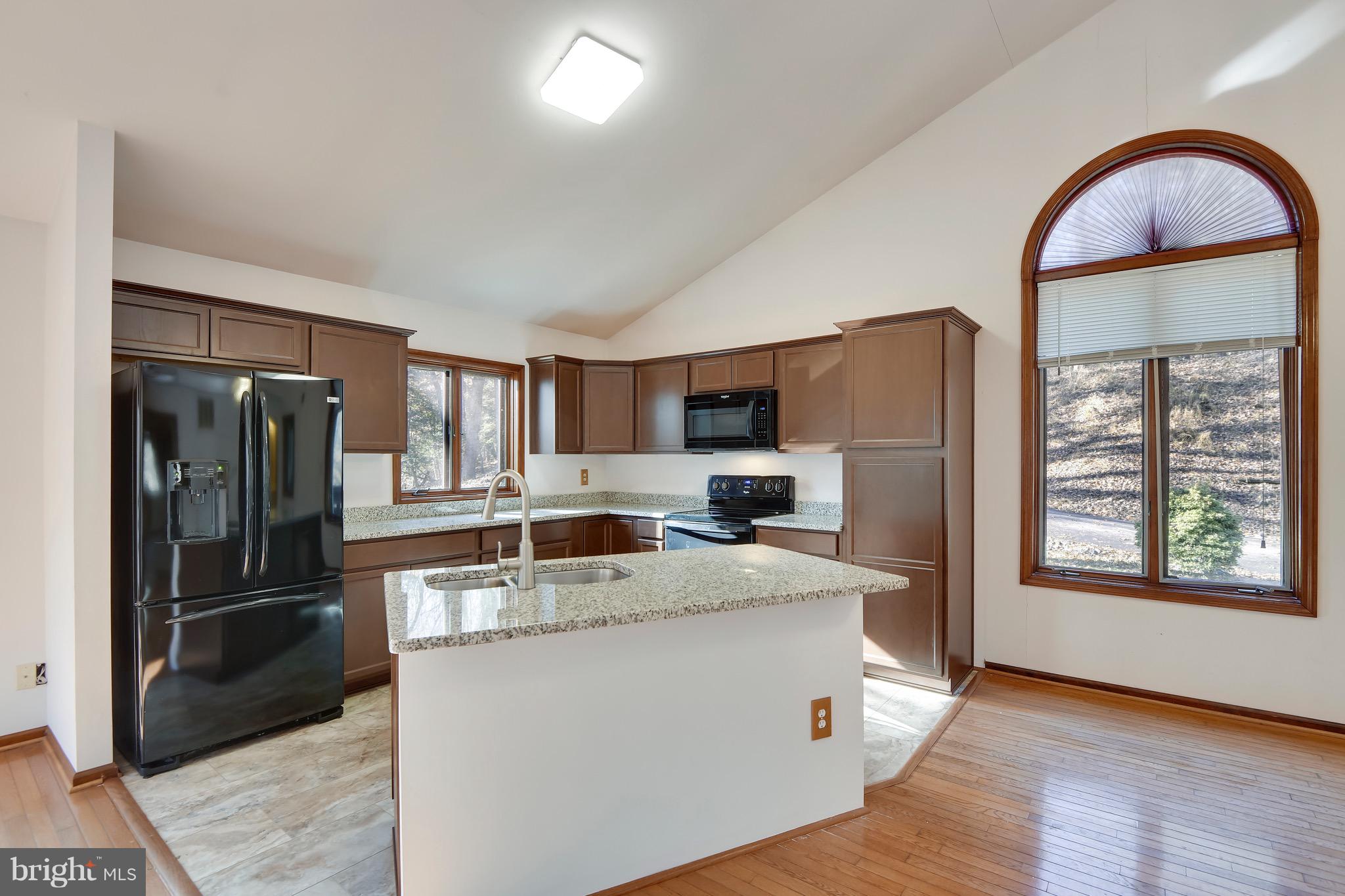 460 Farmington Road West Accokeek, MD 20607 - Photo 12 of 34 a kitchen with stainless steel appliances granite countertop a refrigerator a stove a sink and a large window