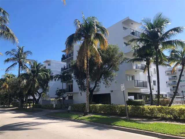 a view of multiple house with palm trees