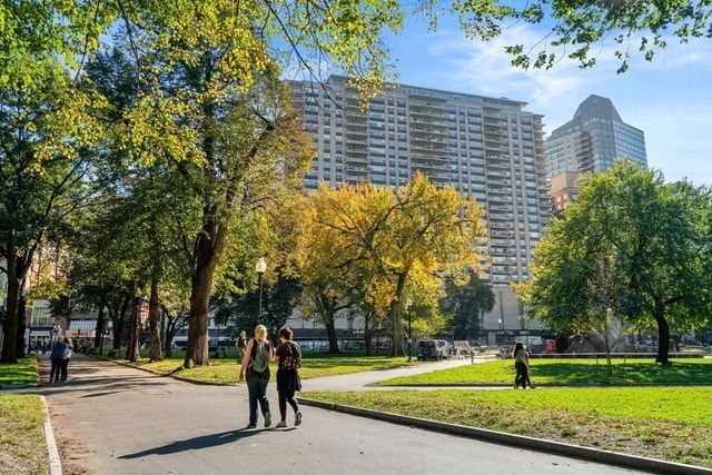 a view of a big building with a big yard and large trees