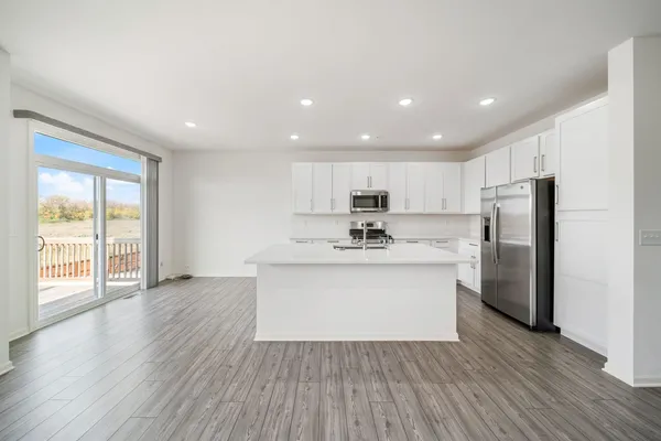 a kitchen with stainless steel appliances a sink and wooden floor