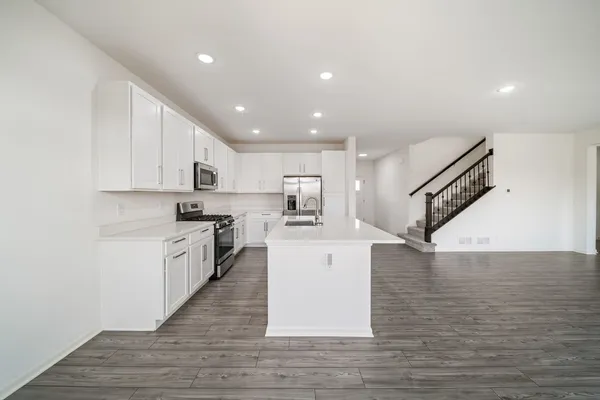 a large kitchen with stainless steel appliances granite countertop a large counter top and a stove top oven