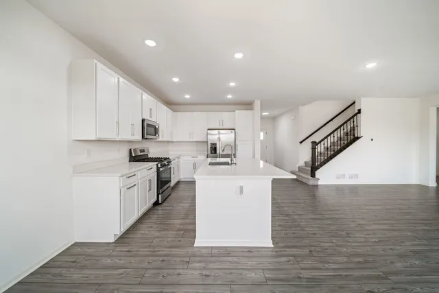 a large kitchen with stainless steel appliances granite countertop a large counter top and a stove top oven