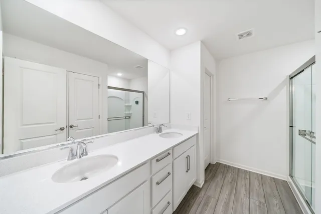 a spacious bathroom with a double vanity sink and mirror