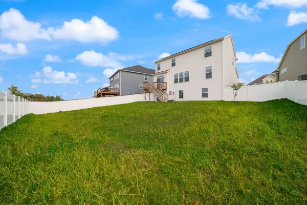 a view of a back yard of the house with a yard