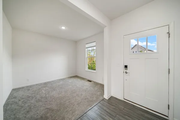 an empty room with wooden floor and window