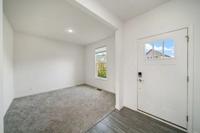 an empty room with wooden floor and window