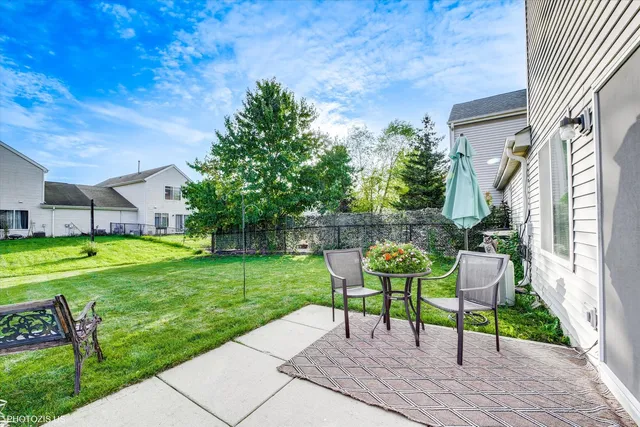 a view of a chair and table in the garden front of the house