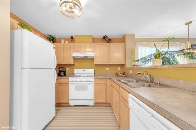 a kitchen with a sink cabinets stainless steel appliances and a counter top space