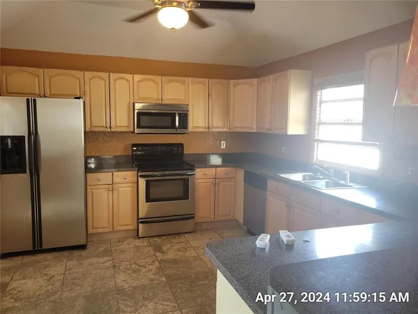 a kitchen with stainless steel appliances granite countertop a stove a sink and a microwave