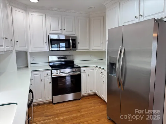 a kitchen with stainless steel appliances and white cabinets