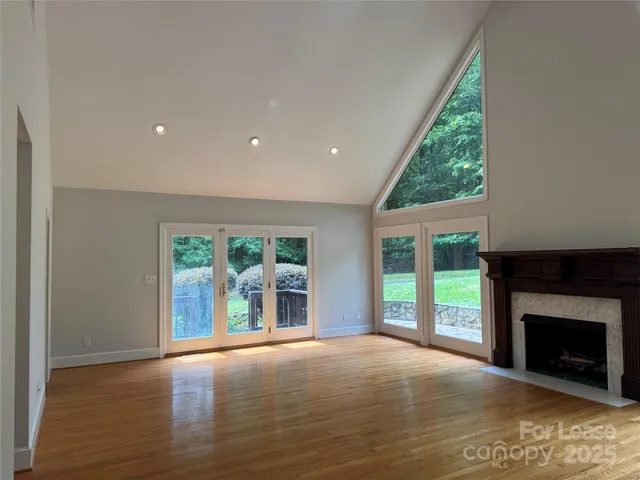 a view of an empty room with a fireplace and a window