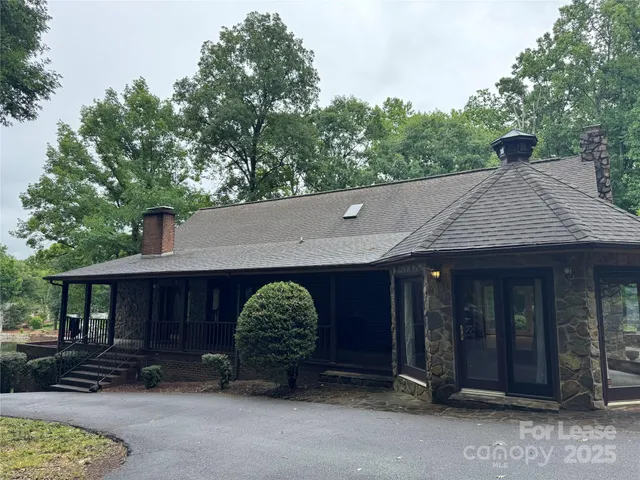 a view of a house with a tub and trees in the background