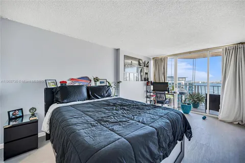 a bedroom with a bed and a large window