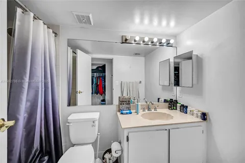 a bathroom with a sink vanity mirror and toilet