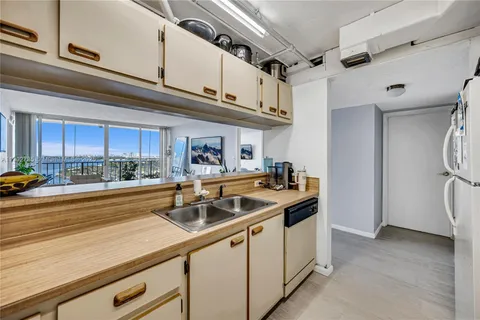 a kitchen with stainless steel appliances granite countertop a sink and a refrigerator