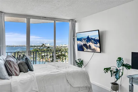 a bedroom with a large bed and a potted plant