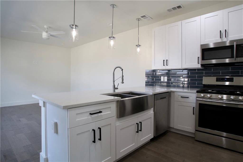 705 Harris Avenue, Unit A Austin, TX 78705 - Photo 19 of 33 a kitchen with stainless steel appliances granite countertop a stove a sink and a microwave