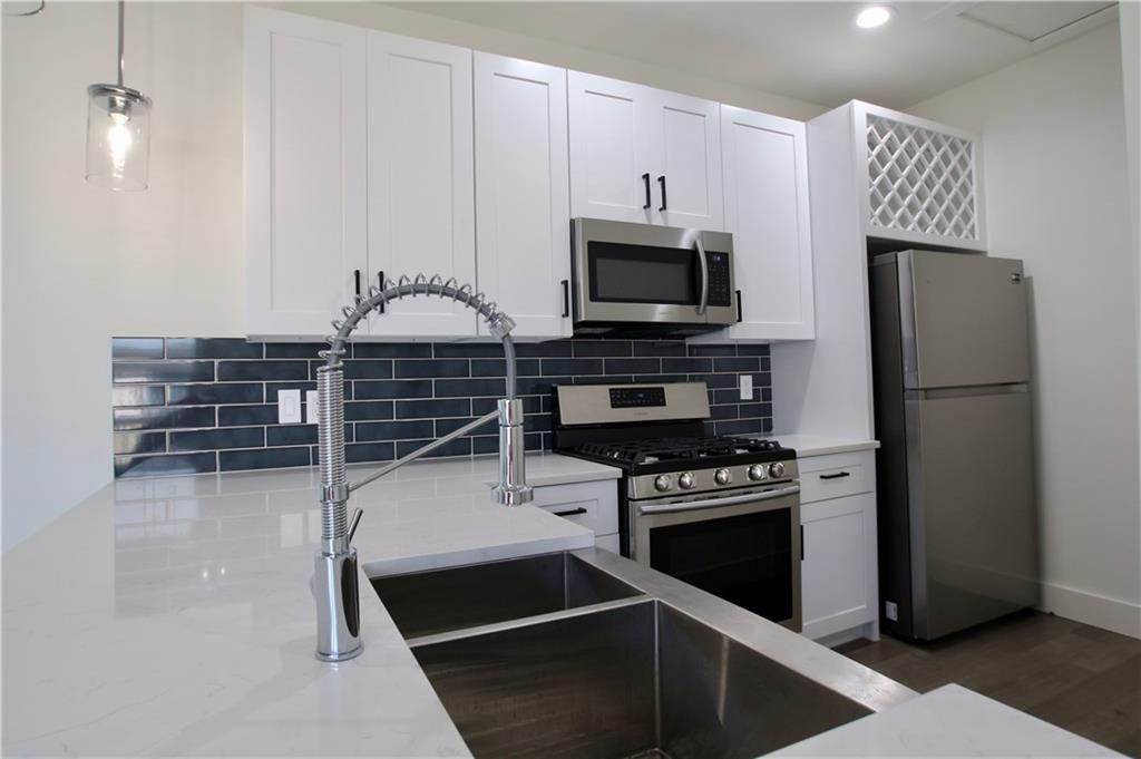 705 Harris Avenue, Unit A Austin, TX 78705 - Photo 20 of 33 a kitchen with stainless steel appliances a refrigerator stove and microwave