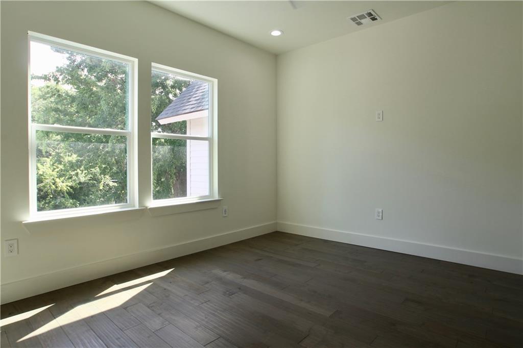 705 Harris Avenue, Unit A Austin, TX 78705 - Photo 27 of 33 an empty room with wooden floor and windows