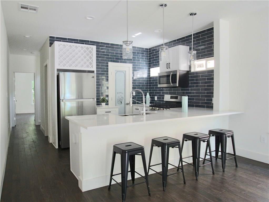 705 Harris Avenue, Unit A Austin, TX 78705 - Photo 4 of 33 a kitchen with cabinets and stainless steel appliances