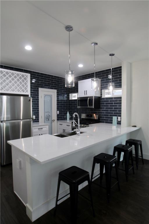 705 Harris Avenue, Unit A Austin, TX 78705 - Photo 5 of 33 a kitchen with kitchen island a dining table chairs and white cabinets