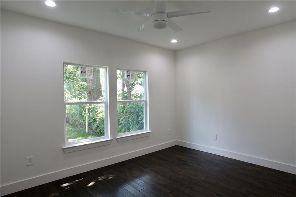 705 Harris Avenue, Unit A Austin, TX 78705 - Photo 8 of 33 an empty room with wooden floor and windows