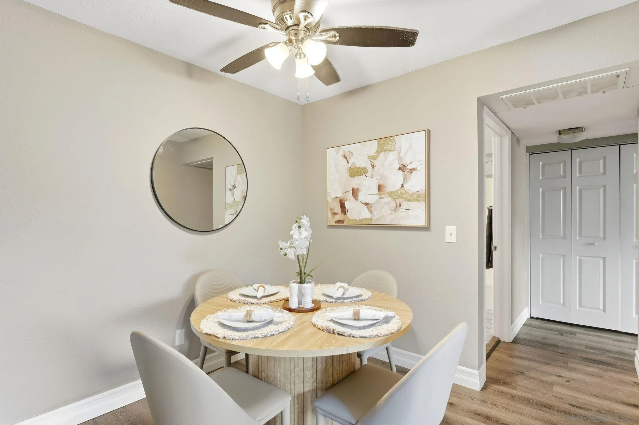 6111 Rancho Mission Road, Unit 209 San Diego, CA 92108 - Photo 5 of 20 a dining room with wooden floor a chandelier fan a wooden table and chairs
