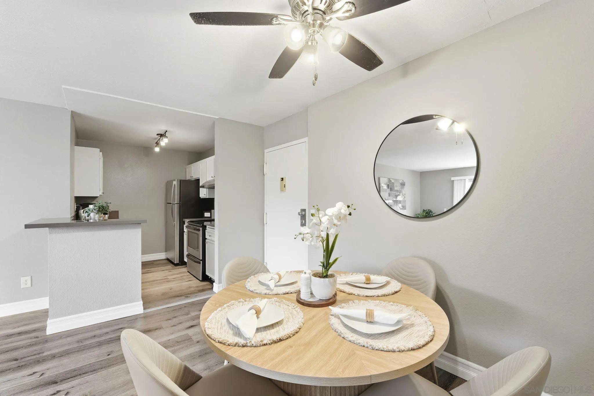 6111 Rancho Mission Road, Unit 209 San Diego, CA 92108 - Photo 6 of 20 a dining room with wooden floor a chandelier a wooden table and chairs