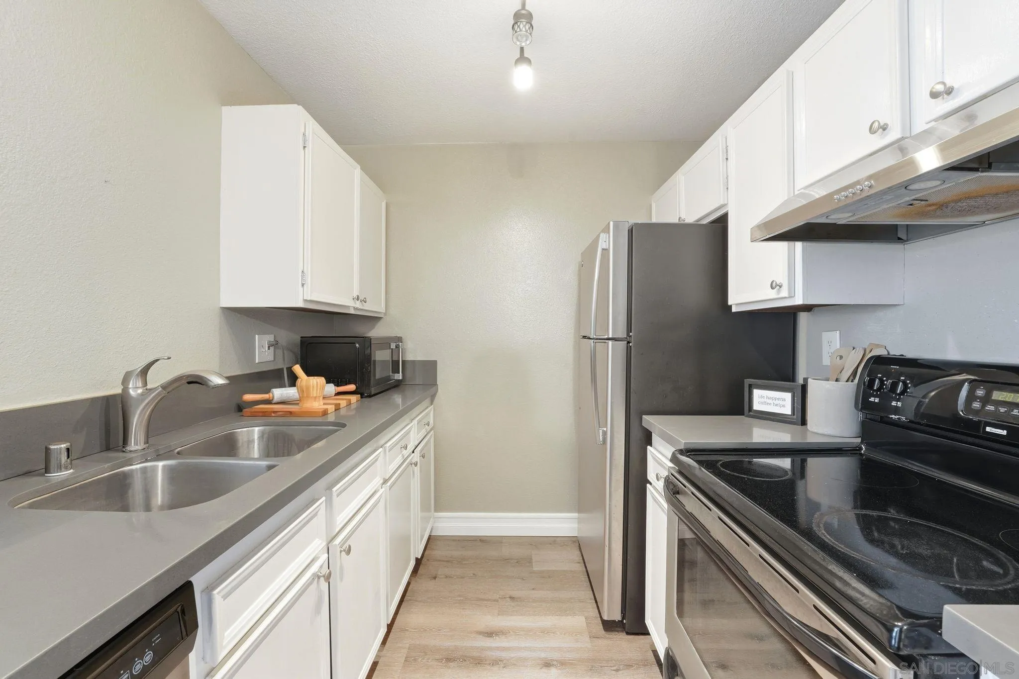 6111 Rancho Mission Road, Unit 209 San Diego, CA 92108 - Photo 9 of 20 a kitchen with stainless steel appliances granite countertop a sink stove and refrigerator