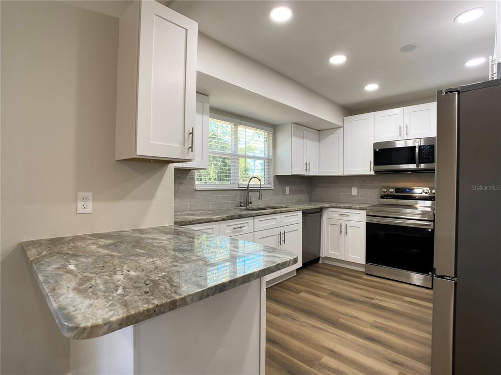 18 Midway Court Ocala, FL 34472 - Photo 21 of 38 a kitchen with stainless steel appliances granite countertop a sink stove and microwave