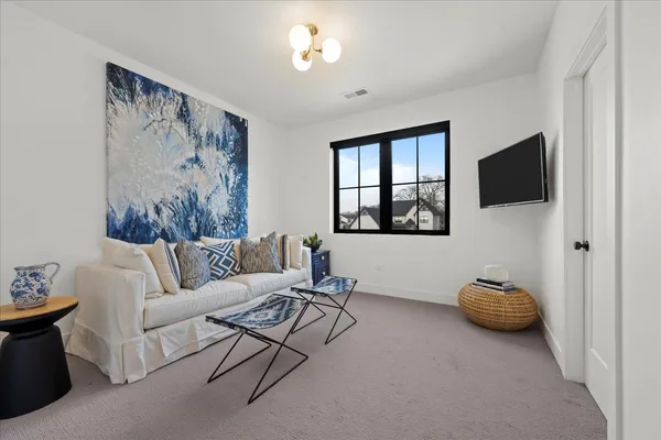 a living room with furniture a window and a flat screen tv