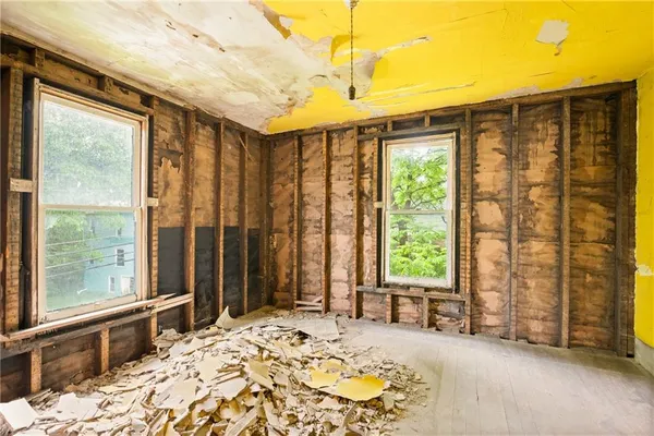 a bed sitting in a spacious bedroom next to a window