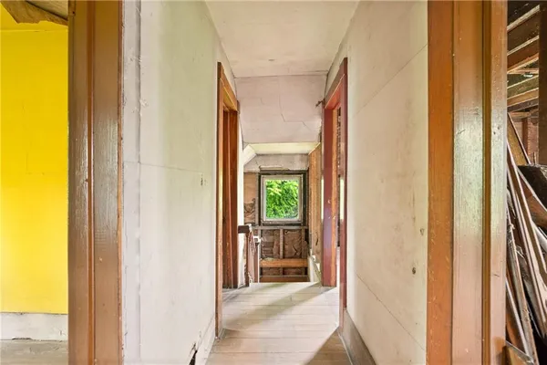 a view of a hallway with wooden floor and a living room