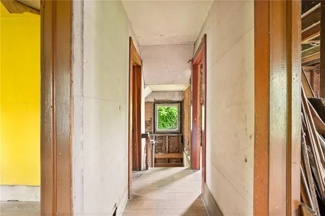 a view of a hallway with wooden floor and a living room