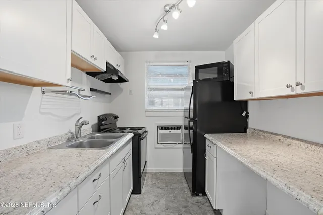 a kitchen with granite countertop a sink stove and refrigerator
