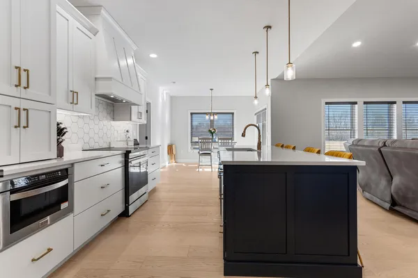 a kitchen with stainless steel appliances sink stove microwave and cabinets